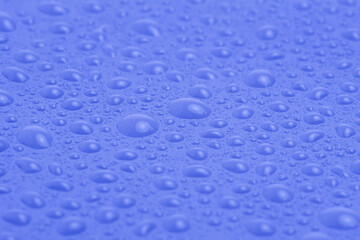 Texture of water drops on purple plastic.