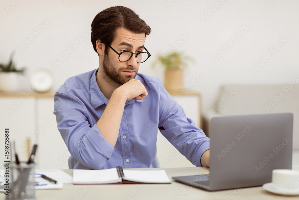 Poster surpirsed business guy in eyewear looking at laptop having computer problem sitting at desk in moder