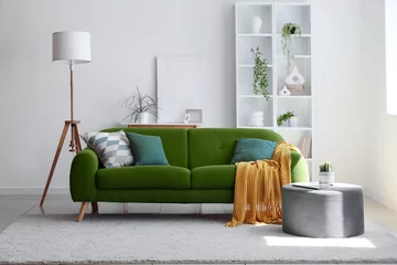 Vitrage gordijnen Cozy green sofa, pouf, shelving unit and floor lamp in interior of light living room © Pixel-Shot