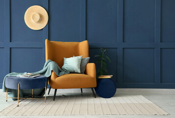 Interior of living room with brown armchair, coffee table, cushions and plaid