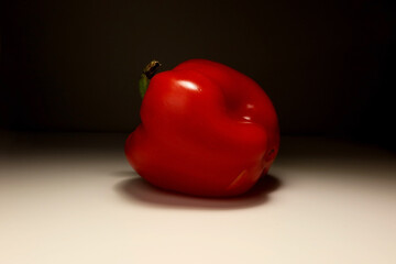 Side view of a red bell pepper with cut stem on white background &ndash; studio lighting, clean minimal food photo for vegetarian, cooking, or healthy eating concept