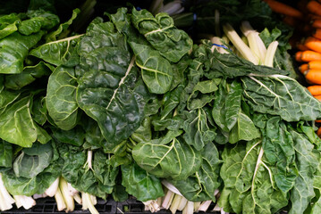 Close-up of fresh chard bunches displayed at a market.