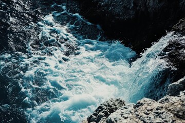 Stunning aerial view of ocean water crashing against rocky coastline: turquoise waves, white foam, dramatic texture