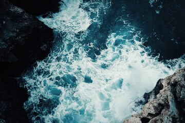 Stunning aerial view of ocean waves crashing against rocky coastline: turquoise waters & white foam