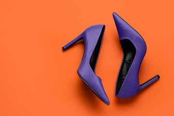 Stylish purple high heels on orange background
