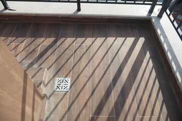 Sunlight casting shadows on a tiled balcony