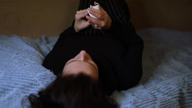 a woman lying on the couch tears up an ultrasound scan of her pregnancy