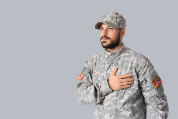 Male soldier praying on light background. Veterans Day celebration