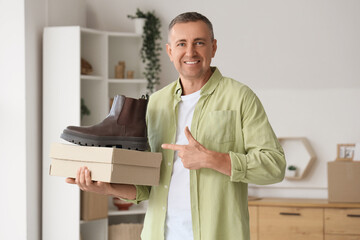 Mature man with new boots and box at home