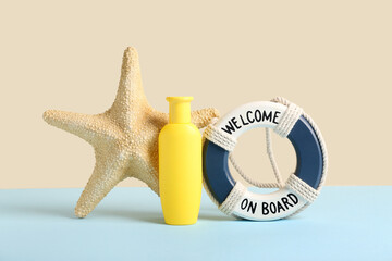 Bottle of sunscreen cream with starfish and lifebuoy ring on colorful background