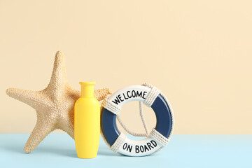 Bottle of sunscreen cream with starfish and lifebuoy ring on colorful background