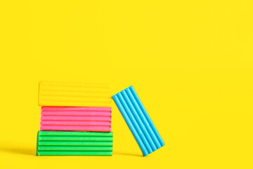 Colorful plasticine on yellow background