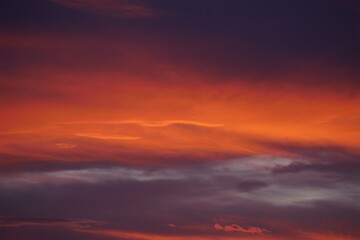 Fototapeta premium vivid orange and purple sunset sky with layered clouds creating a dramatic and serene atmosphere