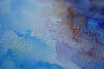 close up of textured watercolor paper with blended shades of blue, purple, and hints of yellow creating a soft, abstract art effect