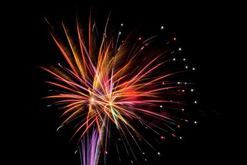 Colorful fireworks exploding in the night sky with bright red, orange, purple, and green streaks creating a festive and celebratory atmosphere