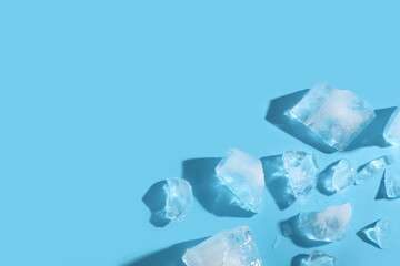 Pieces of frozen ice cubes on blue background