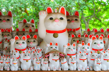 Tokyo, Japan - Sep 30 2024, A close-up view of many multi-sized white beckoning cat figure of Maneki neko with red ears and noses displayed at Gotokuji Temple, without people, at daytime, Tokyo, Japan