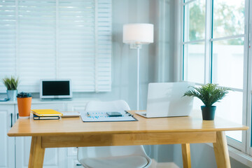 .A clean, modern home office features a laptop, plant, and organized desk, ready for productive...