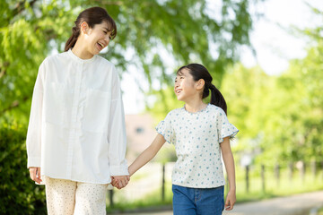 手を繋いで歩く親子