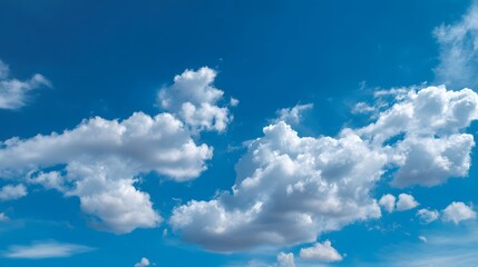 Expansive blue sky dotted with soft wispy clouds in a serene open summer atmosphere