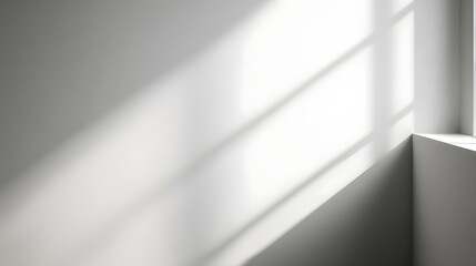 Subtle and calming interior effect with soft window light casting geometric shadows on a plain white wall background creating a minimalist and serene atmosphere