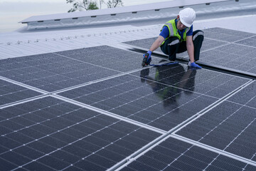 Engineers install solar panels on a wet rooftop during cloudy weather