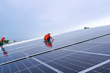 Engineer in safety gear standing on large solar panel rooftop