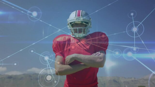 Football player adjusting gear, crossing arms as sports data network appearing showing confidence