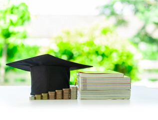 Graduation cap on stacks of coins symbolizes education investment and financial growth.