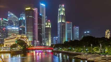 Singapore business district skyscrapers in the night time with water reflections timelapse...