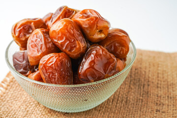 Dates fruit sukari or kurma sukari, in bowl isolated on white background