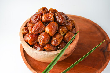 Dates fruit sukari or kurma sukari, in wooden bowl isolated on white background