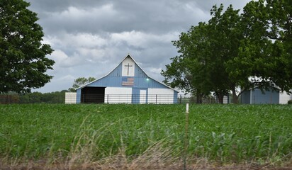 Obraz premium Storm Clouds Over a Blue Barn