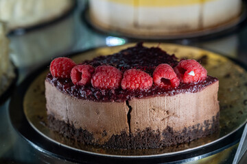 Decadent Chocolate Cake with Fresh Raspberries and Berry Glaze on a Crumbly Base in a Caf? Display
