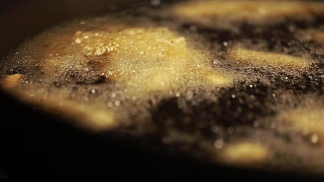 Closeup shot of deep frying potatoes. Oil boiling closeup.