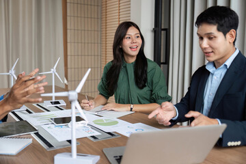 ESG Strategy Meeting. Professionals discussing renewable energy solutions with wind turbines.