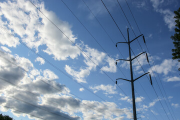 Power lines isolated against a cloudscape abstract modern background.  Steel single-pole overhead...