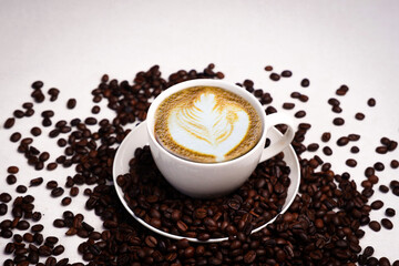 Freshly brewed black coffee in a white cup beside roasted beans on rustic table, capturing morning aroma, warmth, and cozy atmosphere.