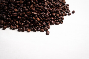 Close-up of roasted brown coffee beans piled together, showcasing rich texture, aroma, and freshness on a white studio background.