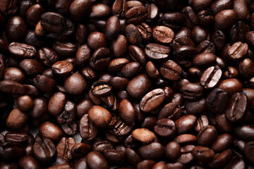 Close-up of roasted brown coffee beans piled together, showcasing rich texture, aroma, and freshness on a white studio background.