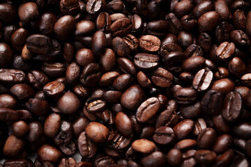 Close-up of roasted brown coffee beans piled together, showcasing rich texture, aroma, and freshness on a white studio background.