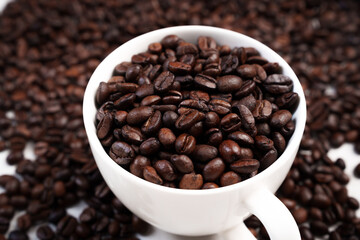 Close-up of roasted brown coffee beans piled together, showcasing rich texture, aroma, and freshness on a white studio background.