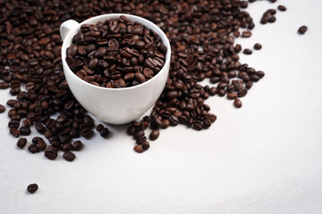 Close-up of roasted brown coffee beans piled together, showcasing rich texture, aroma, and freshness on a white studio background.