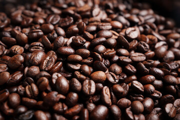 Close-up of roasted brown coffee beans piled together, showcasing rich texture, aroma, and freshness on a white studio background.