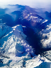 An aerial shot of the Swiss Alps mountain range on a sunny day with blue skies