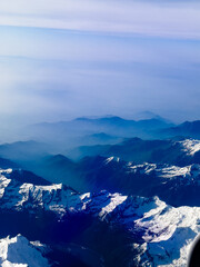 An aerial shot of the Swiss Alps mountain range on a sunny day with blue skies