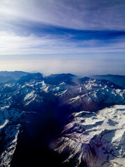 An aerial shot of the Swiss Alps mountain range on a sunny day with blue skies