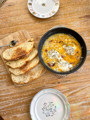Homemade Eggs cooked in cream comfort breakfast on wooden table in natural light 