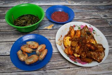 Traditional food with spicy shrimp, boiled egg, fish, stir-fried vegetables and chili sauce.