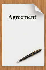 A pen rests beside a piece of paper labeled “Agreement”, suggesting a formal document.